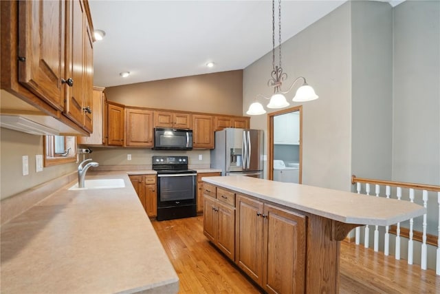 kitchen with washing machine and dryer, light countertops, black range with electric cooktop, stainless steel refrigerator with ice dispenser, and a sink