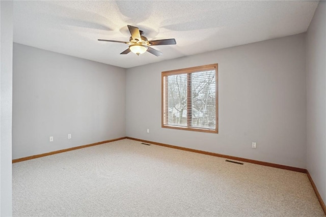 spare room with baseboards, visible vents, ceiling fan, a textured ceiling, and carpet floors