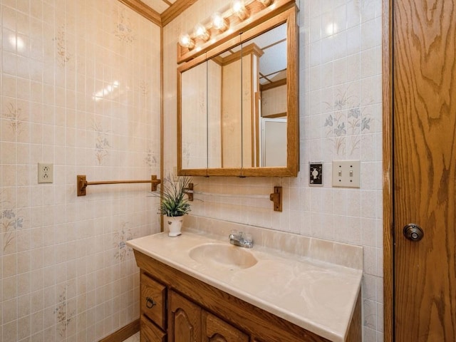 bathroom featuring ornamental molding, tile walls, and vanity