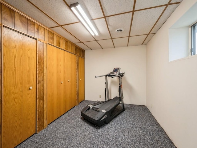 exercise room with carpet floors, a paneled ceiling, and visible vents