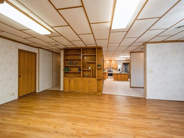 interior space with light wood-style floors and stainless steel fridge