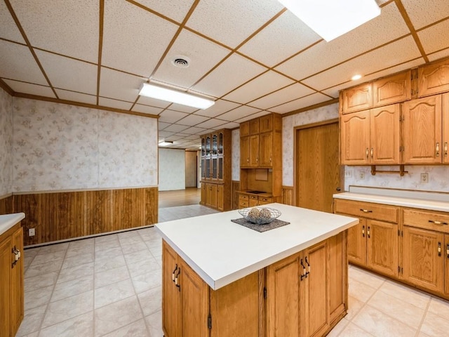 kitchen featuring wainscoting, a paneled ceiling, and wallpapered walls