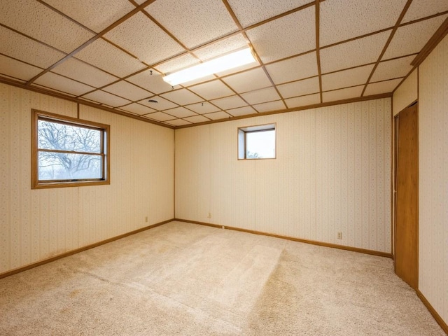 spare room with baseboards, light colored carpet, and wallpapered walls