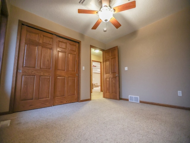 unfurnished bedroom featuring ceiling fan, light carpet, visible vents, baseboards, and a closet