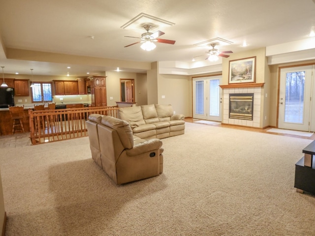 living area featuring ceiling fan, recessed lighting, light colored carpet, and a tile fireplace