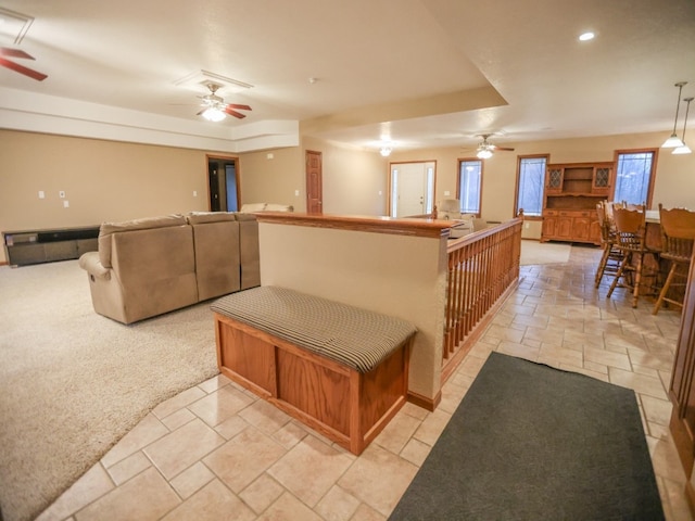 kitchen featuring light carpet, a ceiling fan, open floor plan, stone tile flooring, and recessed lighting