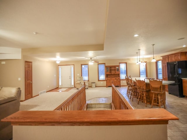 kitchen featuring open floor plan, a kitchen island, freestanding refrigerator, and a healthy amount of sunlight