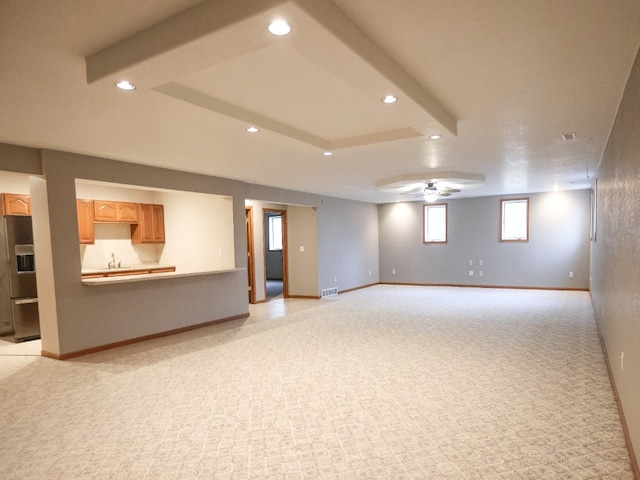 below grade area featuring light carpet, ceiling fan, baseboards, and recessed lighting