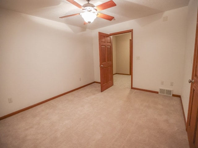 unfurnished bedroom featuring visible vents, light carpet, and baseboards