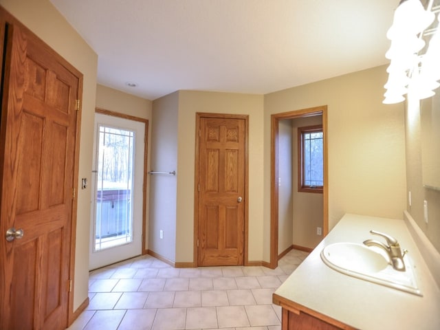 bathroom with a chandelier, vanity, and baseboards