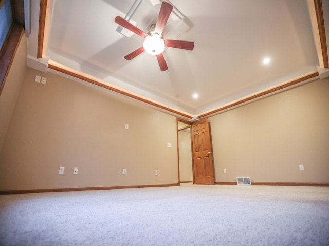 carpeted empty room featuring recessed lighting, a ceiling fan, visible vents, baseboards, and a tray ceiling