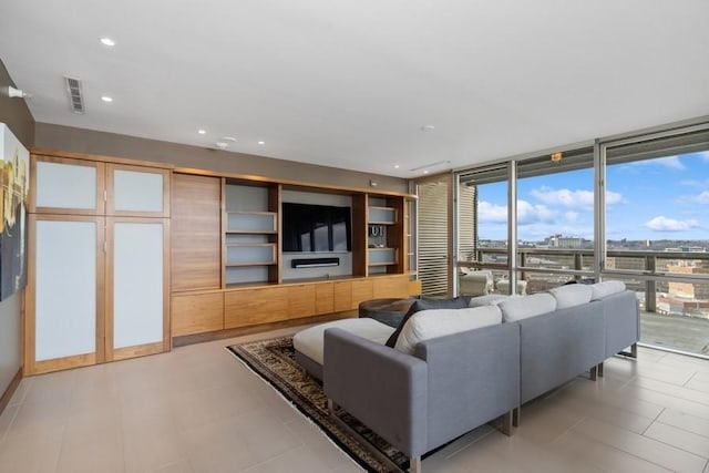 living area featuring a wall of windows, recessed lighting, and visible vents