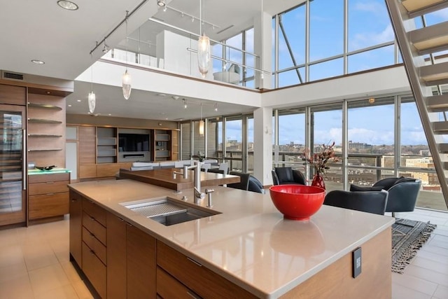 kitchen with a spacious island, a sink, visible vents, open floor plan, and modern cabinets