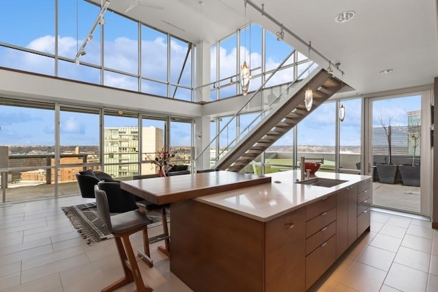 kitchen with plenty of natural light, light tile patterned floors, modern cabinets, and a sink