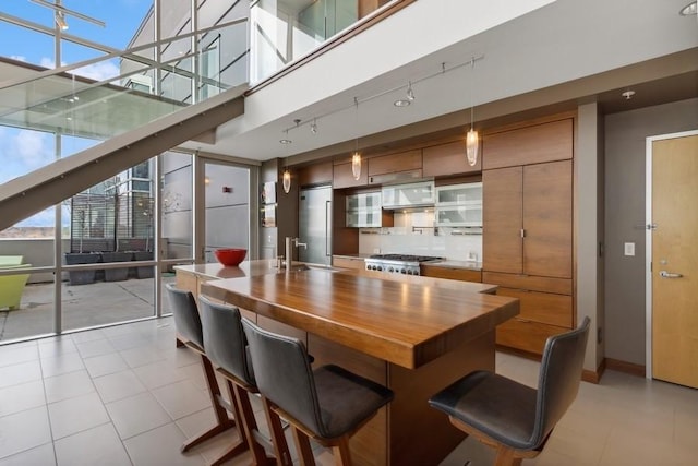 dining area with expansive windows, light tile patterned flooring, a towering ceiling, and baseboards