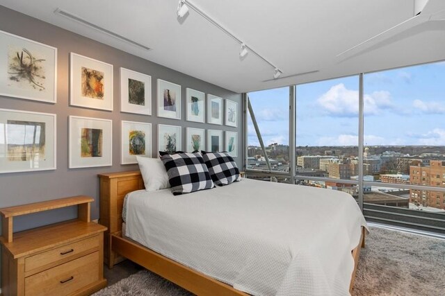 bedroom featuring expansive windows, a city view, and track lighting