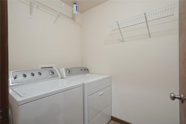 washroom with laundry area, independent washer and dryer, and baseboards