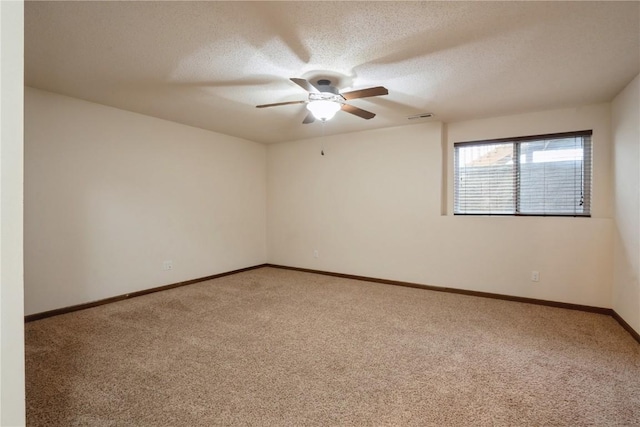 spare room with a textured ceiling, carpet floors, visible vents, and baseboards