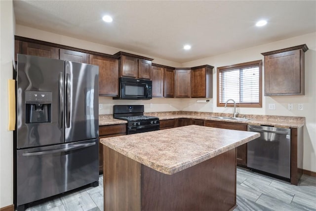 kitchen with a kitchen island, light countertops, dark brown cabinets, black appliances, and a sink