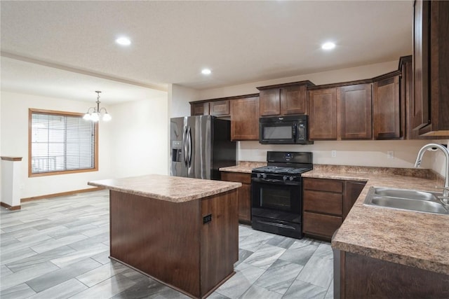 kitchen featuring dark brown cabinetry, a sink, a center island, black appliances, and pendant lighting