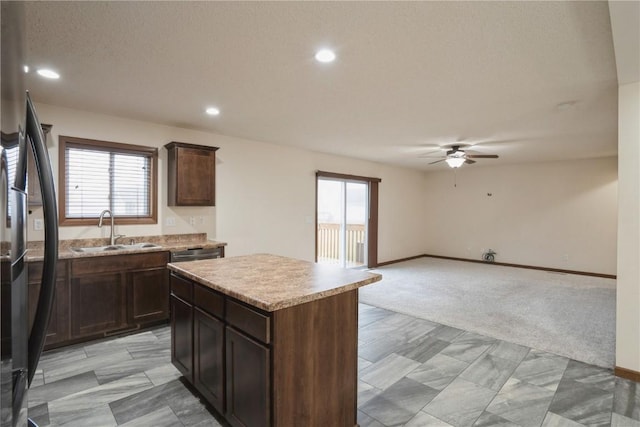 kitchen featuring light carpet, a center island, freestanding refrigerator, light countertops, and a sink