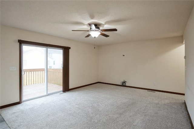 unfurnished room featuring carpet flooring, ceiling fan, a textured ceiling, and baseboards