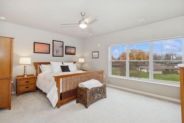 bedroom featuring a ceiling fan, light colored carpet, visible vents, and baseboards