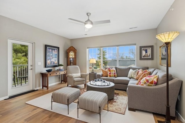 living area with ceiling fan, visible vents, baseboards, and wood finished floors