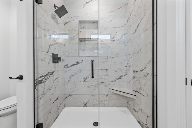 full bath with a marble finish shower and toilet