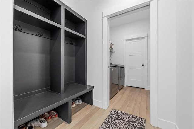 mudroom with light wood-style floors and washing machine and clothes dryer