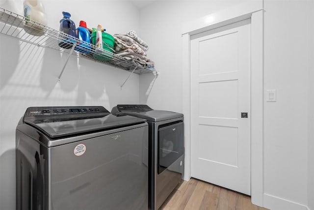 clothes washing area featuring laundry area, light wood-type flooring, and independent washer and dryer