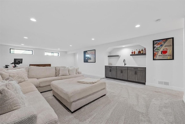 living area featuring wet bar, visible vents, baseboards, and recessed lighting