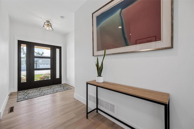 entrance foyer with visible vents, baseboards, and wood finished floors