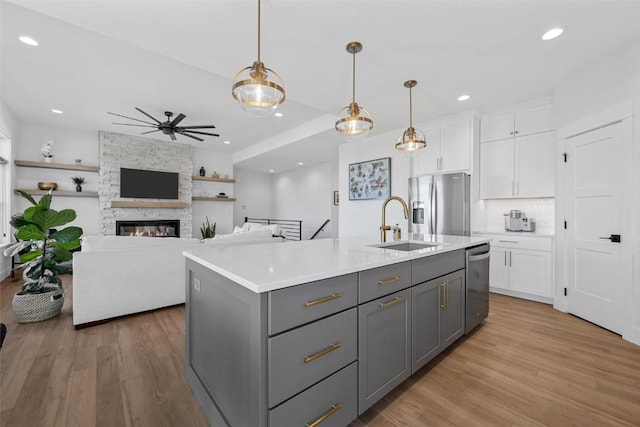 kitchen featuring appliances with stainless steel finishes, light wood-type flooring, gray cabinets, and white cabinets