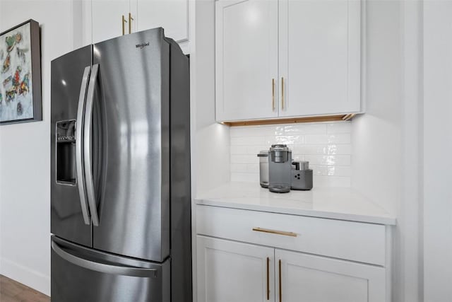 kitchen featuring tasteful backsplash, white cabinetry, and stainless steel refrigerator with ice dispenser