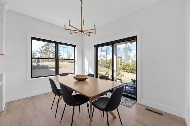 dining room featuring a healthy amount of sunlight, light wood finished floors, and visible vents