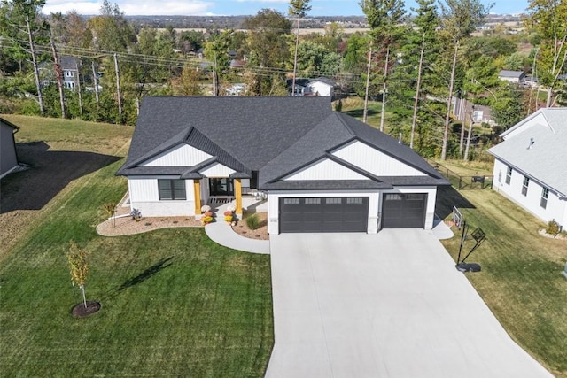 modern farmhouse style home with concrete driveway, a shingled roof, a front lawn, and an attached garage