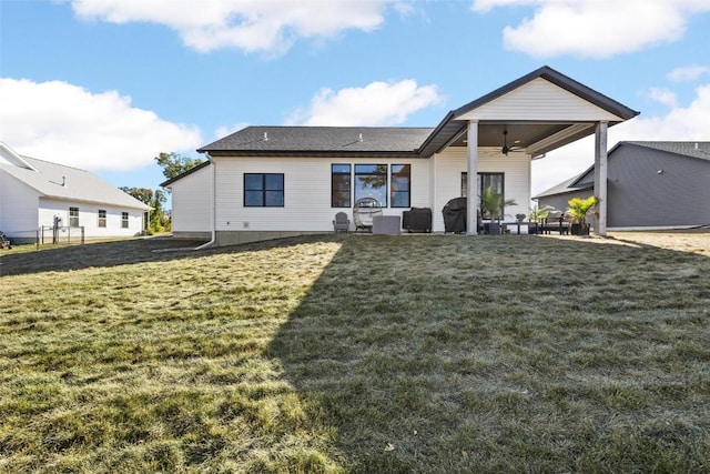 rear view of house with a patio area, a ceiling fan, and a lawn