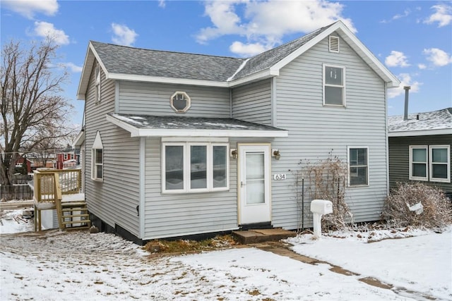 traditional-style home with entry steps and a shingled roof