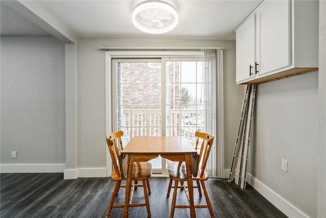 dining space featuring baseboards and dark wood-type flooring