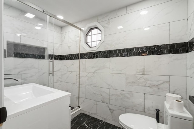 full bathroom featuring marble finish floor, tile walls, toilet, a sink, and a shower stall