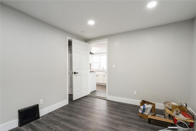 unfurnished bedroom with dark wood finished floors, recessed lighting, visible vents, a sink, and baseboards