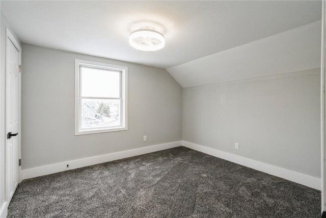 bonus room featuring lofted ceiling, baseboards, and dark carpet