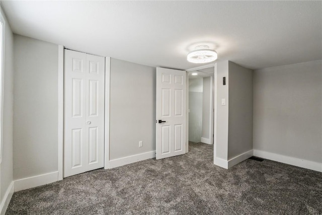 unfurnished bedroom with carpet floors, a closet, and baseboards