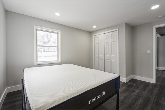 bedroom featuring a closet, baseboards, dark wood-style flooring, and recessed lighting