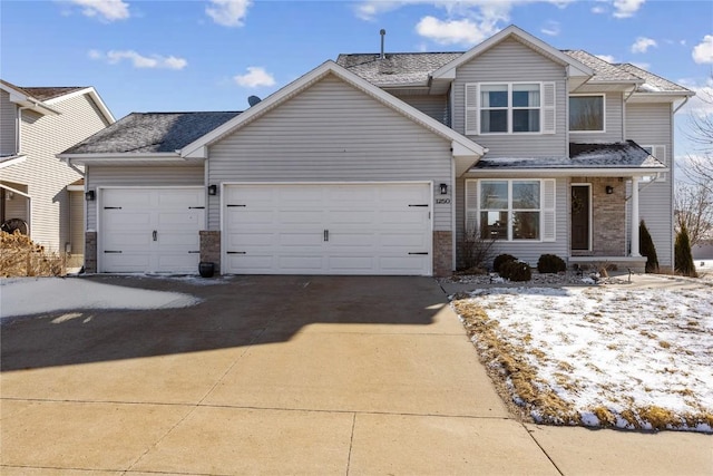 view of front of home with a garage, driveway, and a shingled roof