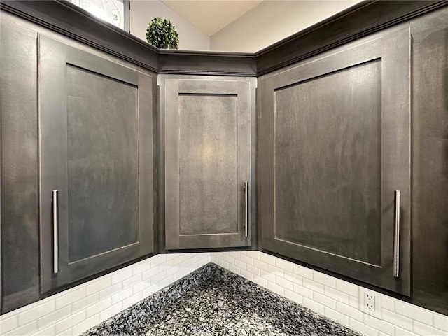 interior space with lofted ceiling and backsplash