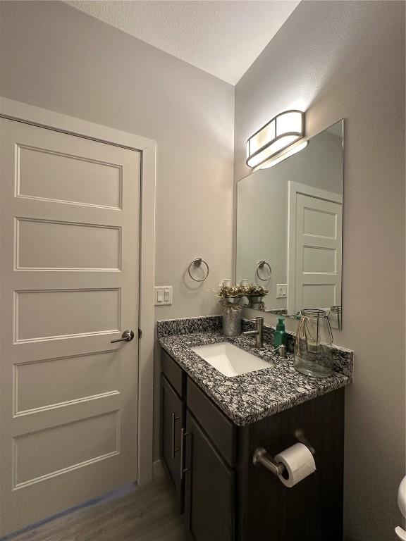 half bathroom with wood finished floors and vanity