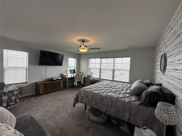 carpeted bedroom with a ceiling fan, multiple windows, and visible vents