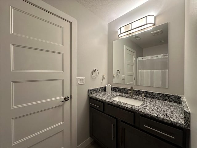 full bath with curtained shower, visible vents, a textured ceiling, and vanity